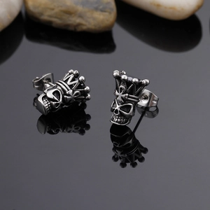 Close-up of gothic skull crown stud earrings with black stones and polished finish