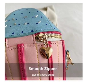 Detail of smooth gold zipper and heart-shaped puller on pink macaron chain bag