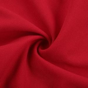 Macro shot of vibrant red chiffon fabric texture with elegant spiraled drapery detail