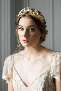 Detailed view of handcrafted golden olive leaf crown headband on model in lace dress