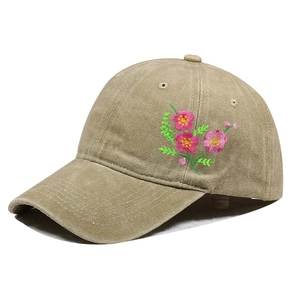 Detail of pink floral embroidery on a khaki cotton baseball cap with premium texture