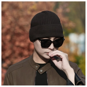 Close-up of deep brown winter knitted beanie showing ribbed texture and folded brim