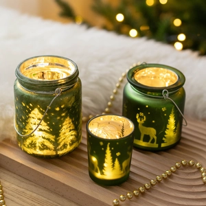 Green frosted glass Christmas candle holders with deer etching and warm LED lights