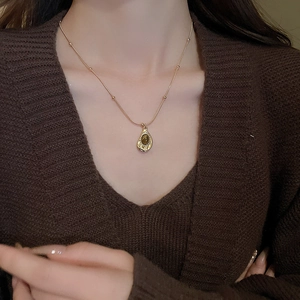 Maillard irregular tiger eye stone necklace with gold chain and drop pendant on a model