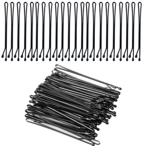 Detailed view of multiple black lacquered metal hair clips neatly arranged on white