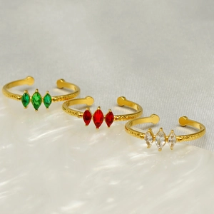 Détail de trois bagues réglables dorées avec pierres taille marquise en vert rouge et blanc