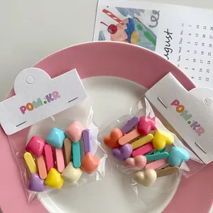 Close-up of candy-colored heart and geometric hair clips for children in a display tray