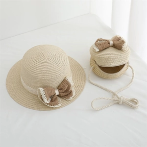 Détail d'un chapeau de paille enfant et sac rond avec dentelle et nœud marron élégant