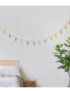 Detail of woven cotton rope hanging chain with colorful metal clips for toy storage