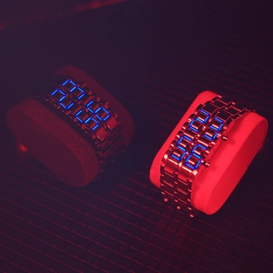 Close-up of futuristic LED watches with metal bands and blue light time display