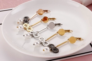 Detailed view of long infinity pearl earrings in gold, silver, rose gold and black finishes