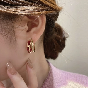 Vintage gold hoop earrings with red velvet chain wrap on female model's ear