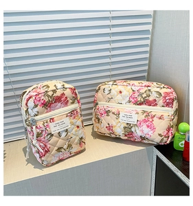 Detailed macro of two floral quilted toiletry bags with elegant flower patterns and zippers
