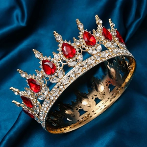 Macro detail of luxury golden bridal crown with red teardrop crystals on silk