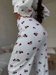 Detail of ribbed knit cherry print pajamas with red lettuce edge hem and slim fit pants