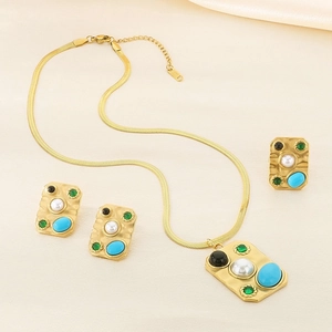 Retro palace style gold jewelry set with turquoise and pearls on satin backdrop