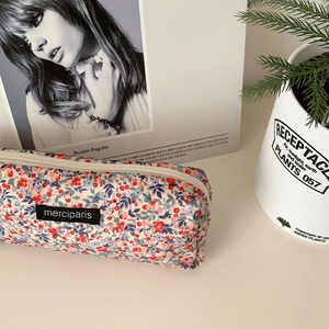 Detailed texture of beige floral corduroy pencil case with elegant red flower patterns