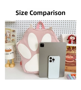 Pink cat paw school bag size comparison with tablet and phone on white desk