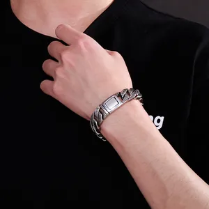 Detail of masculine Cuban link chain bracelet with Greek key pattern and brushed clasp