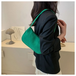 Close-up of green corduroy underarm bag with zipper closure and curved design