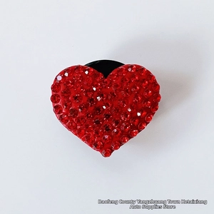 Macro shot of a red heart car aromatherapy clip with sparkling rhinestones and black base