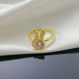 Rotating golden bunny ring with clear zircon and white mother of pearl on silk