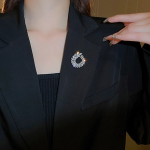 Detail of silver leaf wreath brooch with sparkling white cubic zirconia on a black suit lapel