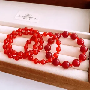 Set of four vintage red agate beaded bracelets in varying sizes inside a jewelry box