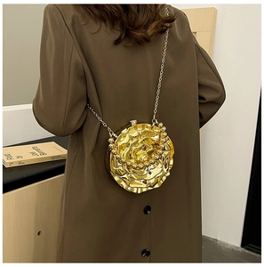 Fashionable rose shaped gold metallic bag with chain strap on a brown coat for women