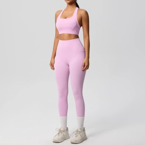 Dettaglio del set yoga rosa con tasca laterale funzionale sui leggings a vita alta