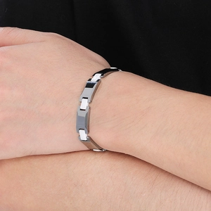 Gros plan d'un bracelet pour homme en tungstène argenté et céramique blanche au poignet