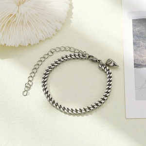 Detail of silver Cuban chain bracelet featuring a heart-shaped magnetic clasp and link