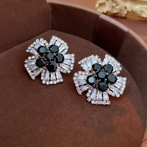 Macro shot of silver needle flower stud earrings with black and white zircon stones