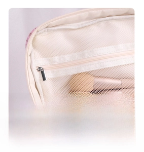 Detail of pink floral makeup bag showing breathable mesh lid pocket for brush storage
