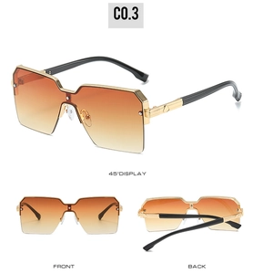 Detail view of oversized square sunglasses with orange gradient lenses and gold metal bridge