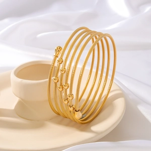 Elegante bracciale rigido dorato a più strati intrecciato con perle su seta bianca