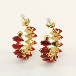 Macro detail of gold earrings featuring red marquise-cut stones on a white background