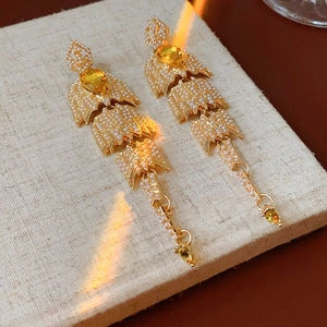 Detail of vintage gold pearl earrings with yellow gemstones and long tassel droplets