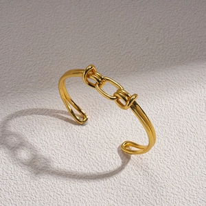 Detailed macro view of 18K gold plated knotted oval link bangle with a minimalist design