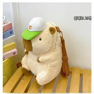 Detail of cute capybara plush bag with C-letter baseball cap on a wooden bench