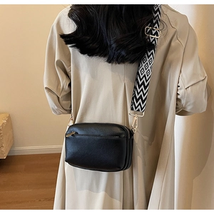 Detailed back view of black lychee texture PU crossbody bag with geometric strap