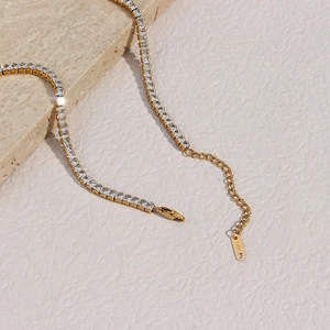 Gros plan d'un collier de tennis doré avec zircons carrés et fermoir mousqueton réglable