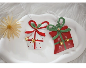 Detail of metal Christmas gift box ornaments with red bows and tiny bells