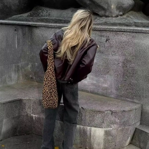 Chic dark brown faux leather bomber jacket with leopard print tote bag in street style
