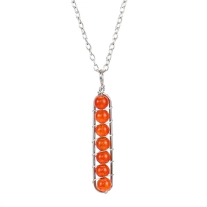 Detail of silver wire wrapped orange beads on a long pendant necklace design