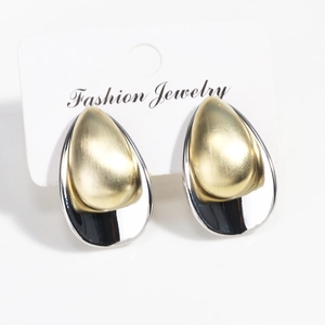 Detail of teardrop earrings featuring brushed gold and polished silver metal contrast