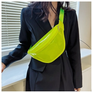 Close-up of neon green PVC chest bag with adjustable strap on black blazer jacket