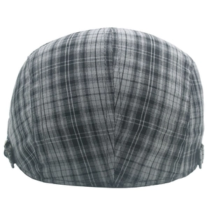 Gros plan d'une casquette gavroche à carreaux noirs et gris avec boucle en métal