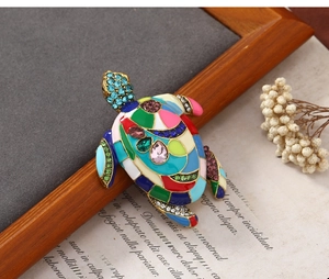 Macro shot of sea turtle brooch featuring colorful enamel and inlaid rhinestones