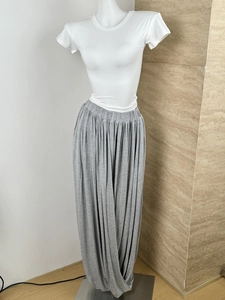 Detailed view of high-waisted pleated gray wide-leg trousers with elastic waistband